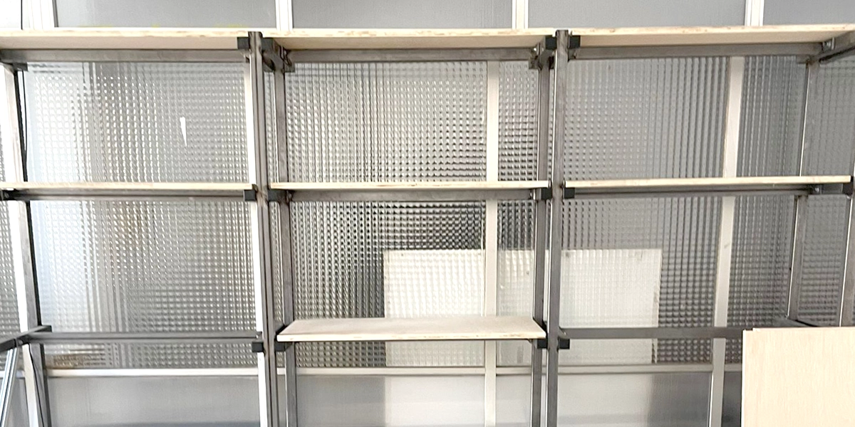 Regal für schwere Lasten aus Stahl, vor einer Glaswand